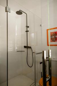 een douche met een glazen deur in een badkamer bij Brut Loft Caminha in Caminha