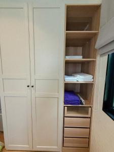 a closet with white cabinets and a tv at FAMILY HOMES HALO, brand new 2-bedroom Apartment with Pool Access in Phuket