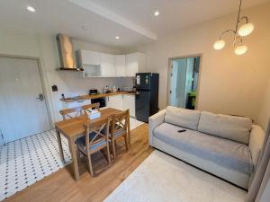 a living room with a couch and a table and a kitchen at FAMILY HOMES HALO, brand new 2-bedroom Apartment with Pool Access in Phuket +16 photos