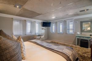 une chambre avec un lit dans une pièce avec des fenêtres dans l'établissement Thesen Harbour Town Apartments @ Beautiful Knysna Villas, à Knysna