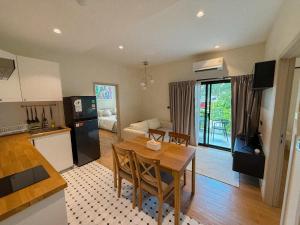 a kitchen and dining room with a table and a kitchen and a living room at FAMILY HOMES Halo - Brand New 2BDRM Poolside Apartment in Phuket