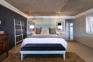 - une chambre avec un grand lit et deux miroirs dans l'établissement Thesen Harbour Town Apartments @ Beautiful Knysna Villas, à Knysna