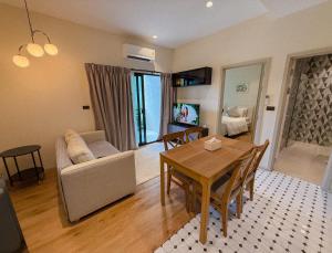 a living room with a table and a couch at FAMILY HOMES HALO, brand new 2-bedroom Apartment with Pool Access in Phuket