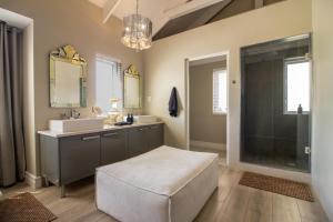 une salle de bain avec deux lavabos et un grand miroir dans l'établissement Thesen Harbour Town Apartments @ Beautiful Knysna Villas, à Knysna 22 autres photos
