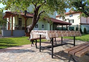 a picnic table in front of a building with a tree at Simada Green Guesthouse in Varshets