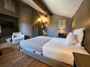 a bedroom with a large white bed and a chair at La Divine Comédie-Suites Deluxe in Avignon