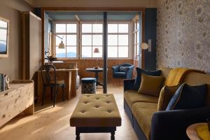 a living room with a couch and a table at Berghoferin Fine Hotel & Hideaway in Redagno