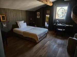 a bedroom with a bed and a desk and a window at La Divine Comédie-Suites Deluxe in Avignon