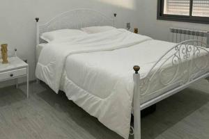 a bedroom with a white bed with a white comforter at 1 Bed Flat - Sleeps 2 - Parking - Wifi in Tunis +8 photos