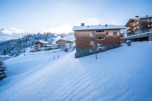 a snow covered parking lot in front of a building at Landal Brandnertal in Bürserberg
