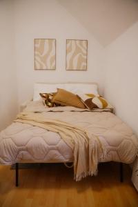 a bed in a bedroom with two pictures on the wall at Ferienwohnung zur kleinen Grede in Herborn