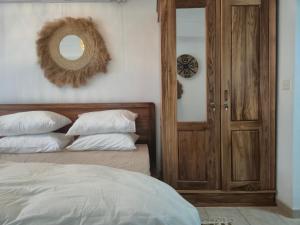 a bedroom with a bed with white pillows and a mirror at Studio Amorisca Peaceful 2-Person Stay in Flic-en-Flac