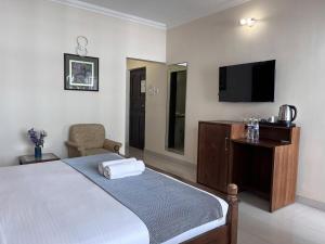 a hotel room with a bed and a tv at Ora Stays by Q 23 - Near to Fortune Select Candolim in Candolim