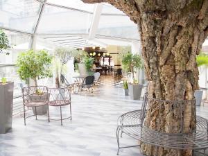 Ario con sillas y un árbol en un edificio. en Ibis Paris Tour Eiffel Cambronne 15ème, en París
