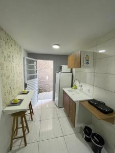 a kitchen with a sink and a refrigerator at Studio 107 in Sao Paulo