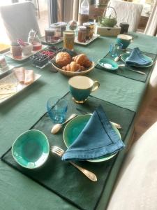 a green table with plates and utensils on it at BB les pieds dans L'eau CARANTEC in Carantec +7 photos