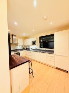 a large kitchen with white cabinets and a wooden floor at Tower Bridge Apartments in London
