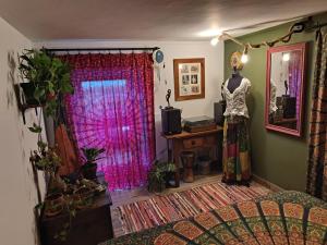 a room with a bed and a window with pink curtains at This Old House in Ponta do Pargo +33 photos