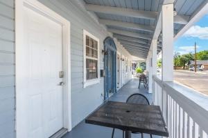 a porch with a wooden bench on a white house at The Cowboy Social Unit 3 in Williams +27 photos