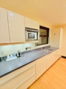 a kitchen with a sink and a microwave at Tower Bridge Apartments in London