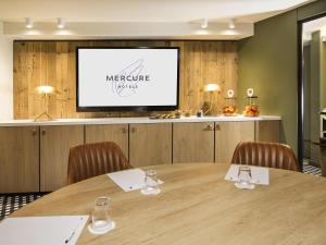 a meeting room with a table and a projection screen at Mercure Chambéry Centre in Chambéry