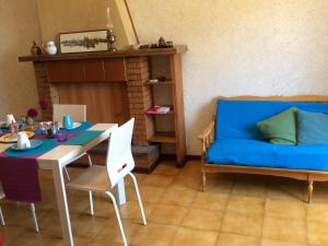 a living room with a blue couch and a table at Villa Giuditta in SantʼAngelo in Pontano