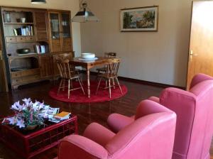a living room with pink chairs and a table at Villa Giuditta in SantʼAngelo in Pontano