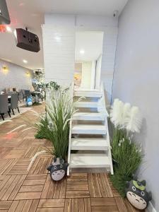 Una escalera en una habitación con plantas en PulauKetam HuaHeeHomes 吉胆岛欢喜亲子民宿, en Bagan Teochew