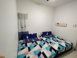 a bedroom with a bed with blue and white at Happy Homestay Cameron Jaya in Cameron Highlands