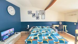 a bedroom with a bed and a desk and a clock at Le Photographe Cosy Douai centre in Douai