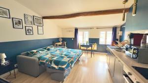 a bedroom with a bed and a kitchen with a counter at Le Photographe Cosy Douai centre in Douai