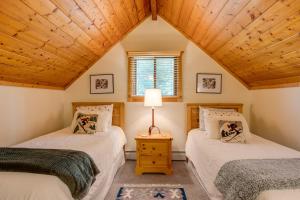 two twin beds in a room with a wooden ceiling at Mtn-View Deck Stunning Fraser Home By Ski Shuttle in Maryvale