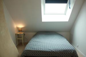a small bedroom with a bed and a window at Gîte 'Le 31' in Coulaines