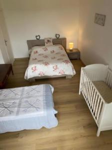 FromentièresにあるGîte Comme Chez Soi En Champagneのベッドルーム(ベッド2台、ベビーベッド1台付)