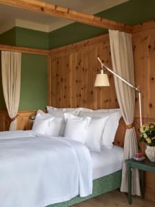 une chambre avec un lit avec des oreillers blancs dans l'établissement Berghoferin Fine Hotel & Hideaway, à Redagno