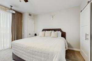 a white bedroom with a large bed with white sheets at The Lodge at Stillwater #2012 in Heber City