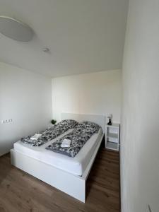 イフラヴァにあるApartmán ERUDITO Královský vršek Jihlavaの部屋にベッドが置かれた白い寝室