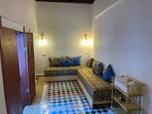 a room with a couch with blue pillows on it at Riad la Mentha in Fès