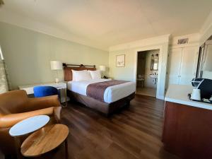 a hotel room with a bed and a living room at Bayfront Inn in Saint Augustine