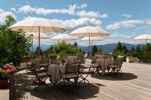 un groupe de tables et de chaises avec parasols dans l'établissement Berghoferin Fine Hotel & Hideaway, à Redagno