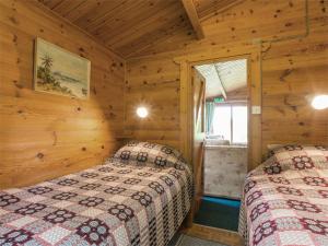 two beds in a log cabin bedroom with wooden walls at 2 Bed in Ardeonaig CA351 in Ardeonaig