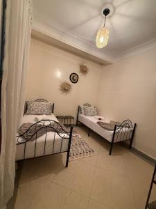 a bedroom with two beds in a room at front of beach apartement taghazout in Taghazout