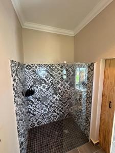 a shower with a black and white patterned wall at La Vita Farm Stay in Wellington