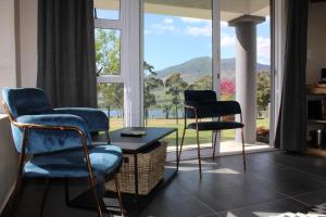 two chairs and a table in front of a window at La Vita Farm Stay in Wellington