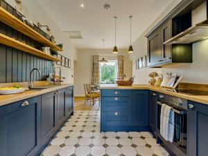 Una cocina grande con gabinetes azules y una mesa. en 2 Bed in Richmond 83085, en Barton