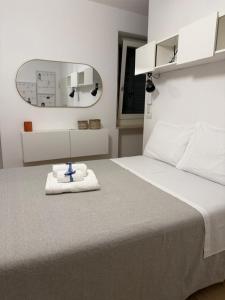 a bedroom with a white bed with a blue cross on it at Le Casette in Macerata