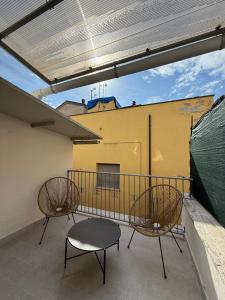 a balcony with two chairs and a table at Le Casette in Macerata +2 photos