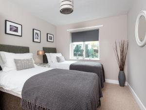 Un dormitorio con dos camas y una ventana. en 4 Bed in Borrowdale SZ219, en Grange