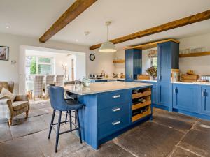 a kitchen with blue cabinets and a blue island at 4 Bed in Sedbergh SZ595 in Milnthorpe