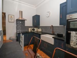 une cuisine avec des armoires bleues et un évier dans l'établissement Flat 2 23 Hyde Park Road, à Harrogate 12 autres photos